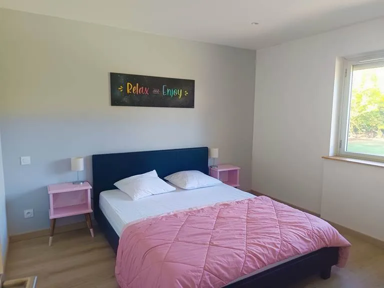Chambre lumineuse avec lit double, tête de lit rétroéclairée et bureau