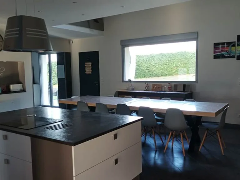 Cuisine ouverte du gîte Grand Balazin avec îlot central, plaques à induction et grande table à manger