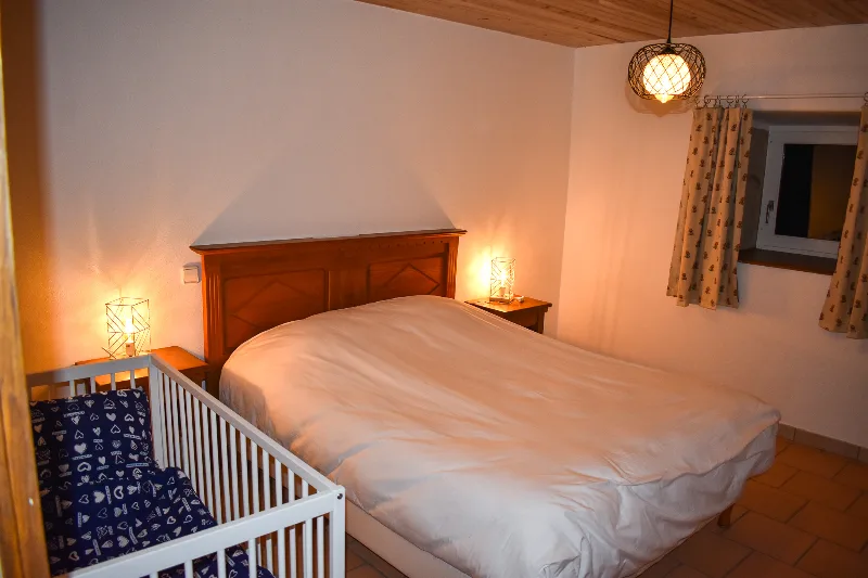 Chambre avec lit double et berceau bébé à disposition
