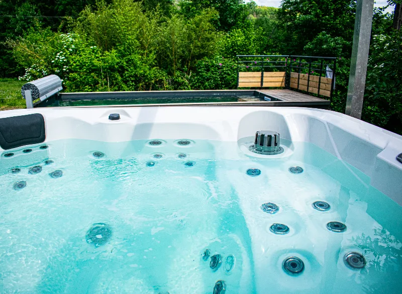 Bain à remous extérieur entouré d'arbres dans le jardin