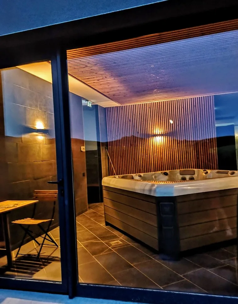 Spa extérieur éclairé de nuit avec vue dégagée sur les montagnes