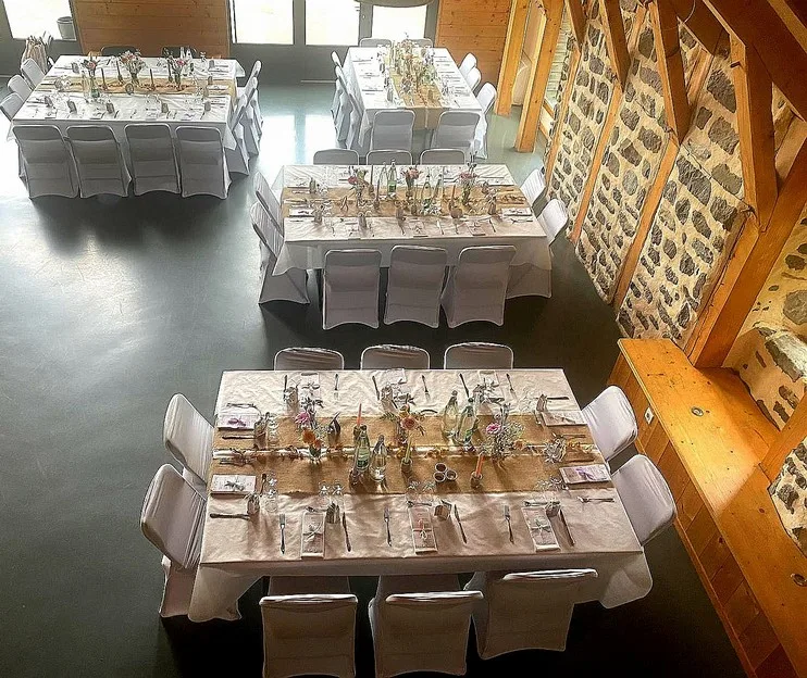 Grande salle de réception avec tables dressées pour un événement de groupe