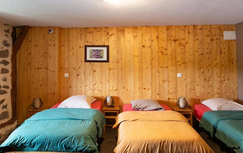 Chambre à l'étage avec trois lits simples côte à côte