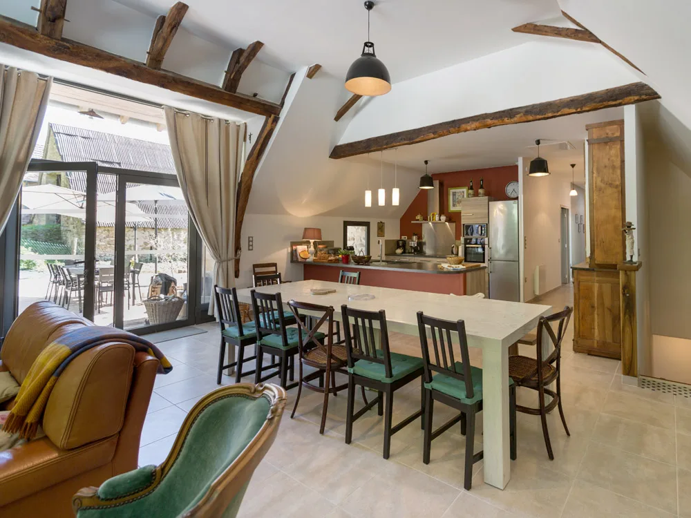 Salle à manger et cuisine ouverte sous charpente en bois