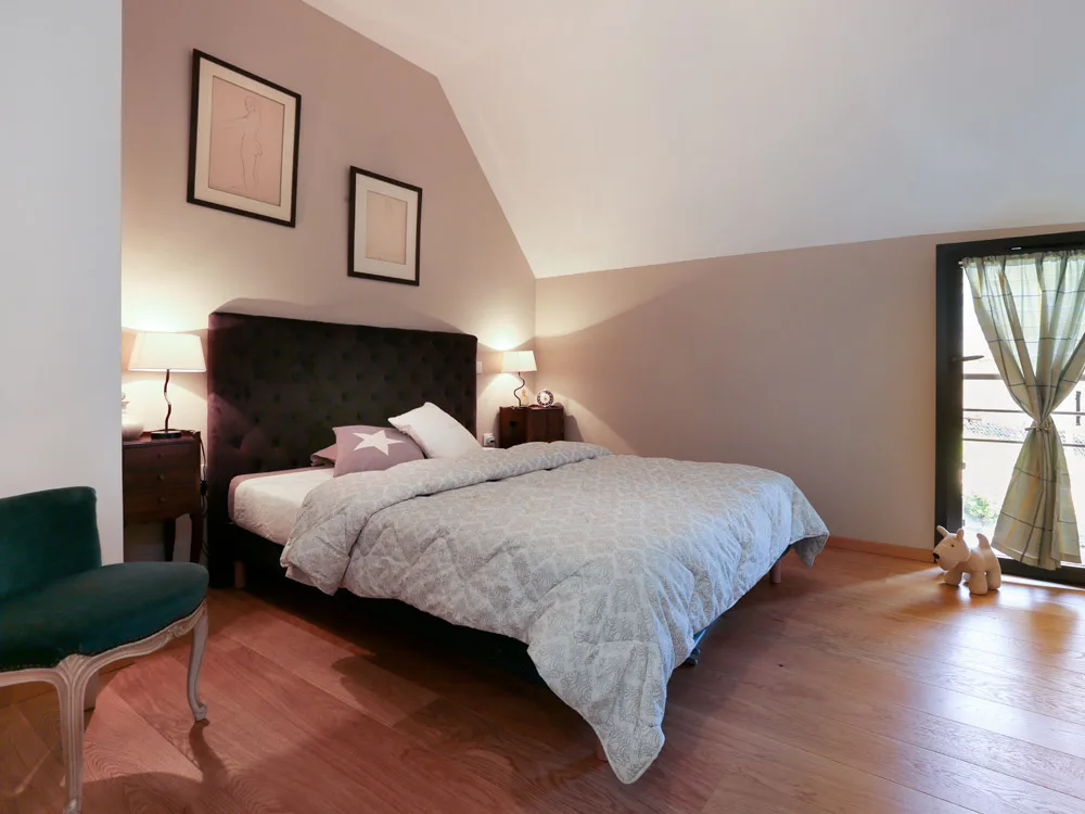Chambre avec lit double sous toiture mansardée