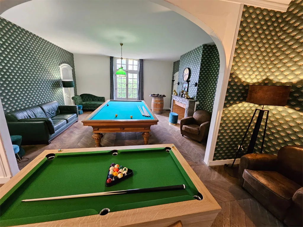 Salle de billard avec tapis vert, mobilier cosy et papier peint à motifs dorés