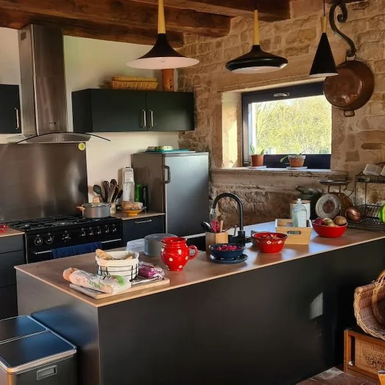 Cuisine en pierre entièrement équipée avec îlot central, plaques de cuisson et rangements
