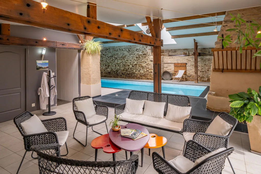 Terrasse couverte en bois donnant sur la piscine, avec chaises longues pour se détendre en famille
