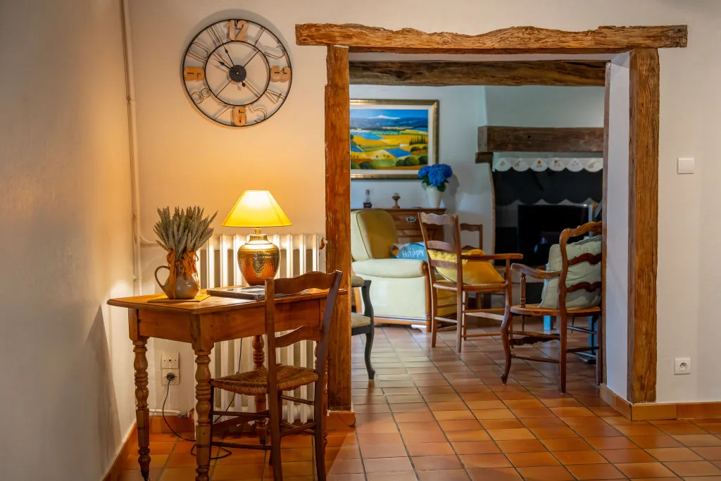 Petit salon avec cheminée, tableau et mobilier en bois dans une ambiance chaleureuse