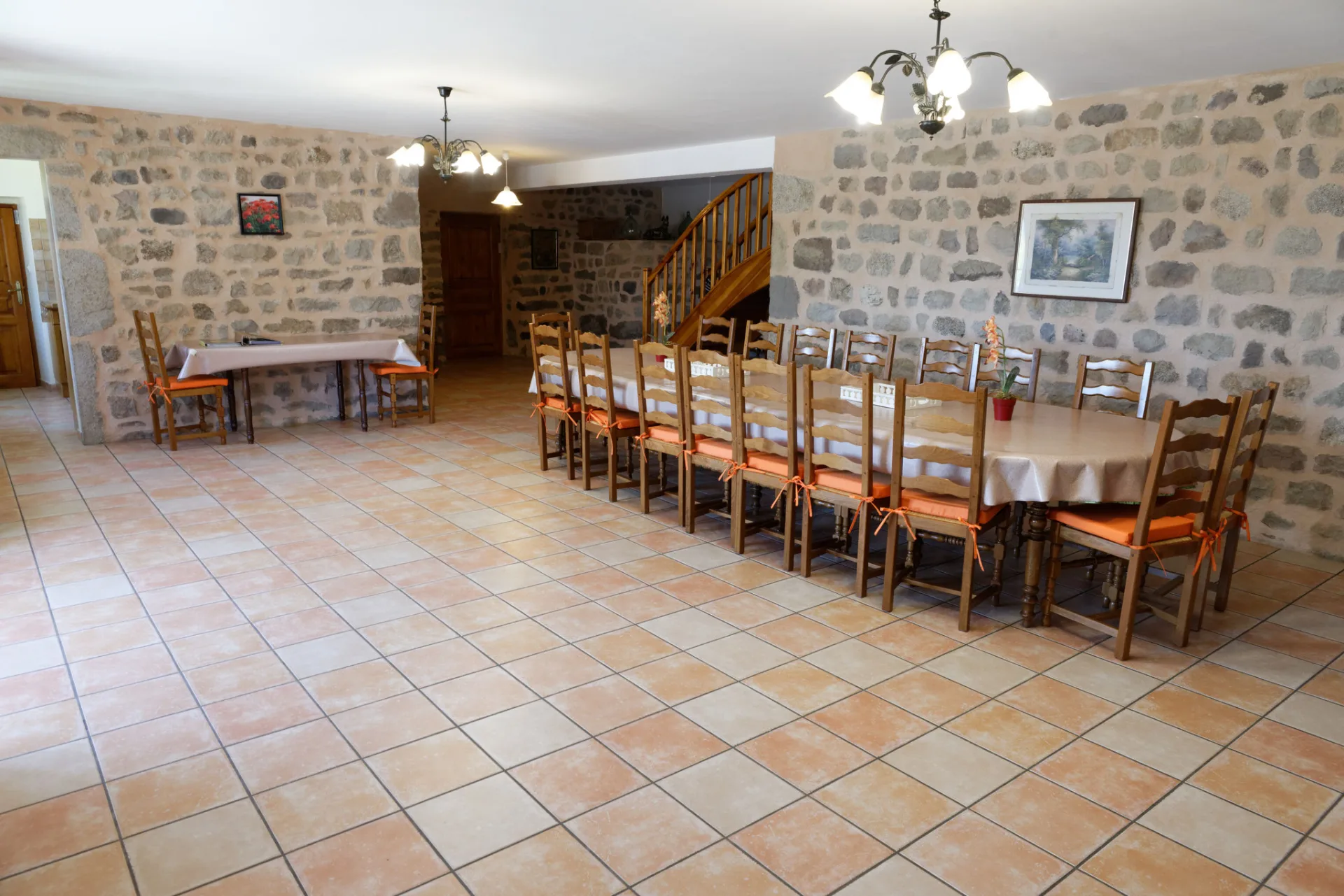 Grande salle à manger avec table en bois pouvant accueillir une quinzaine de convives