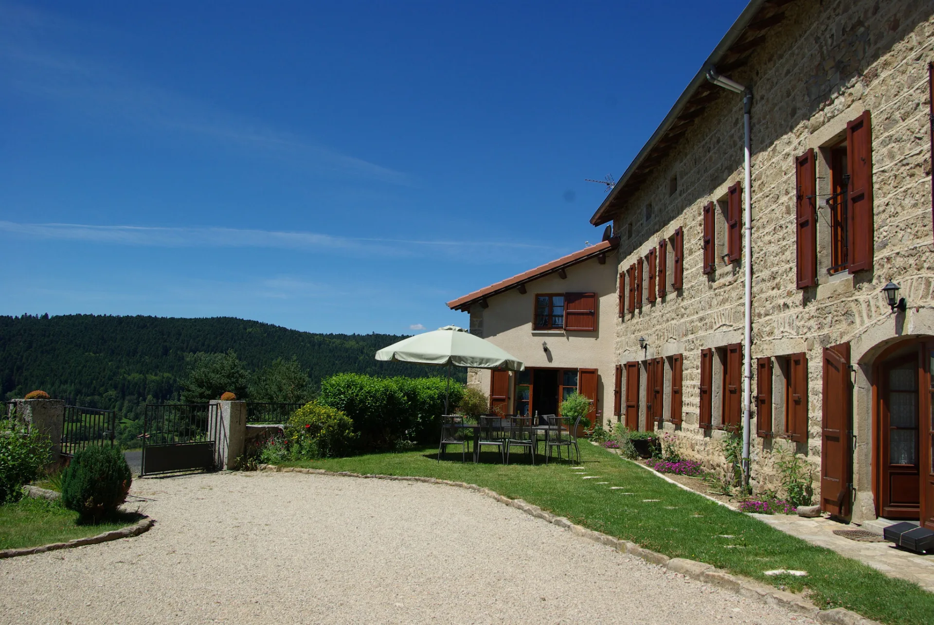 Façade et terrasse extérieure du gîte, murs en pierre typiques du plateau du Forez
