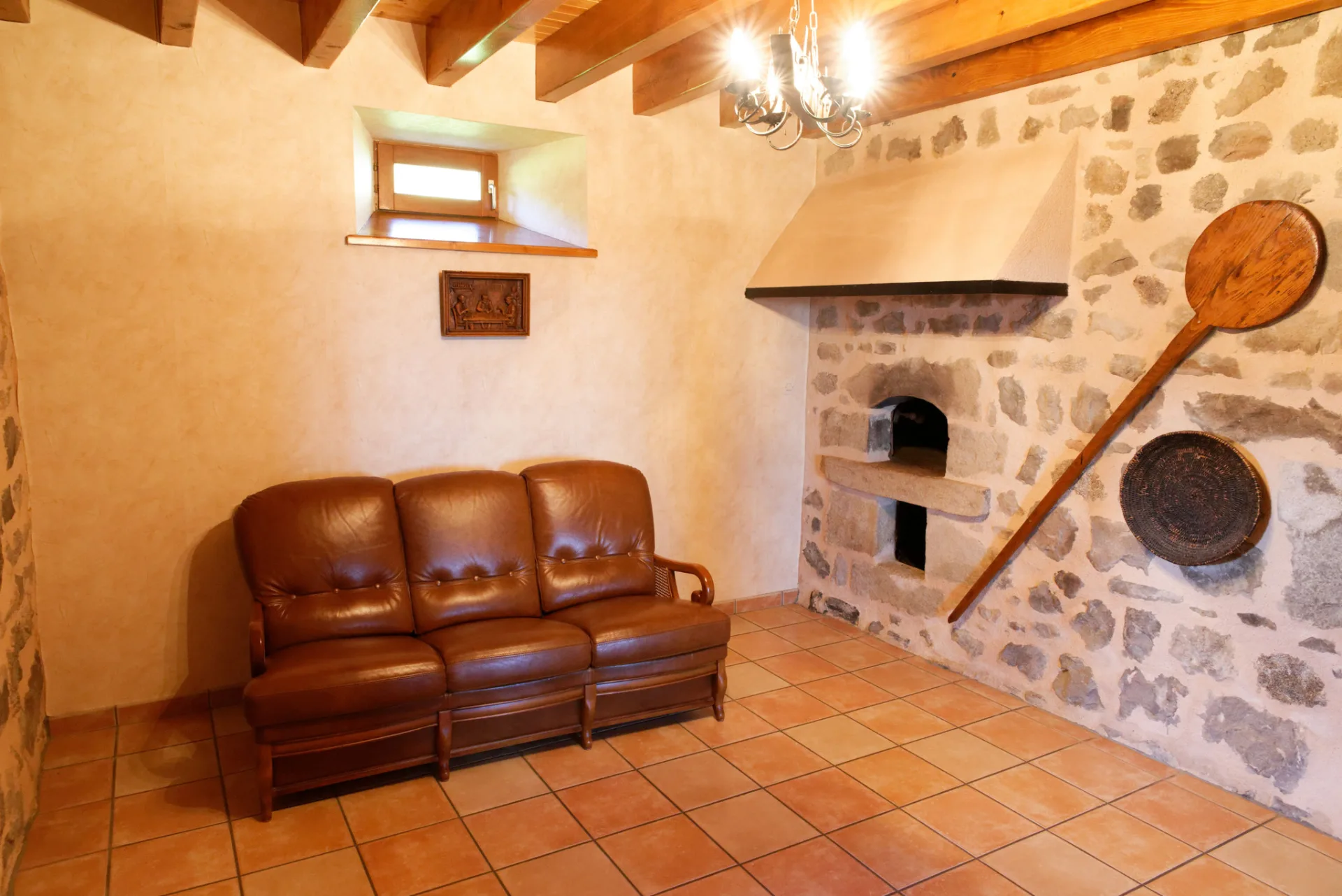 Coin four à pain ancien en pierre avec canapé en cuir dans un espace de détente