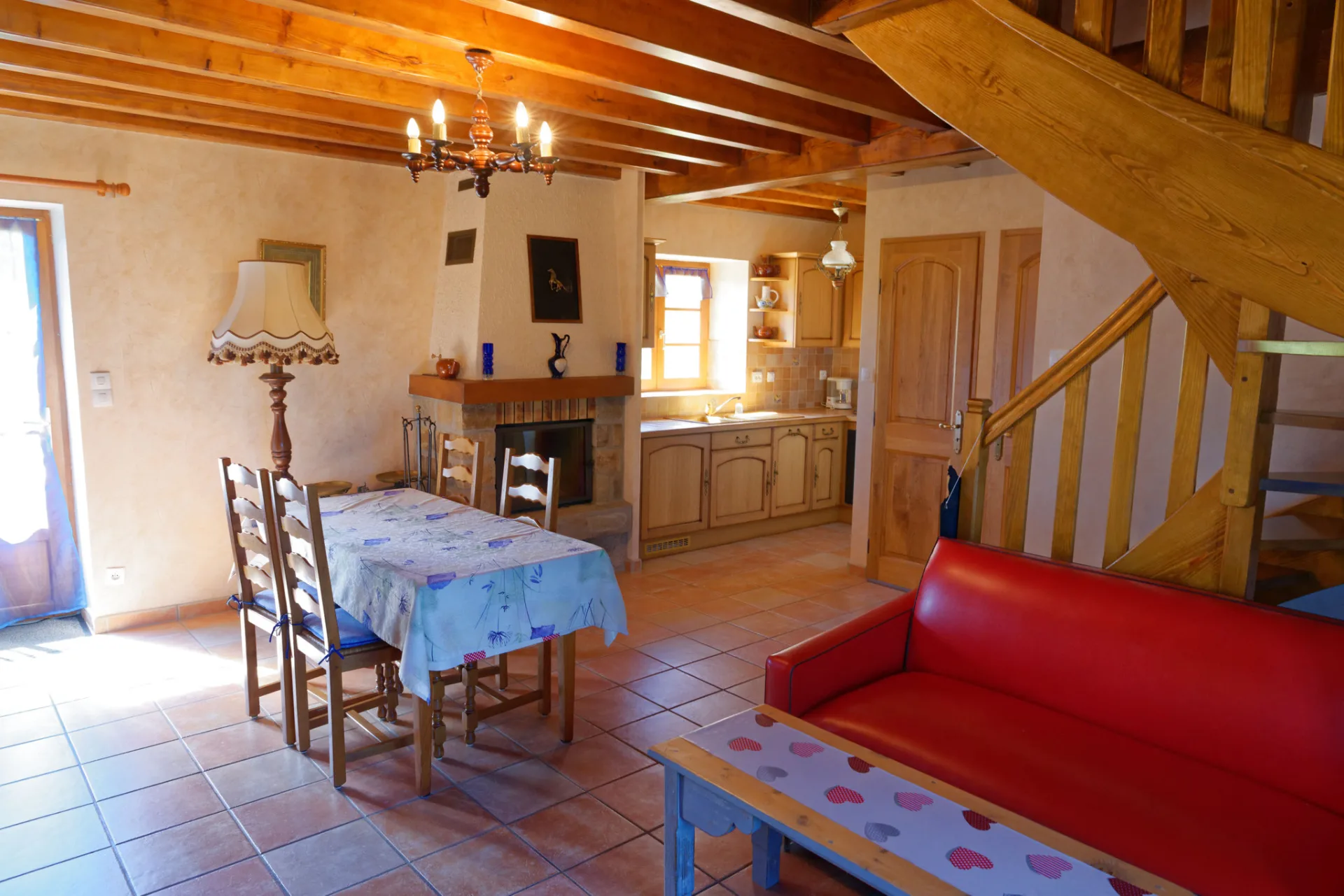 Cuisine avec coin repas et escalier en bois menant à l'étage