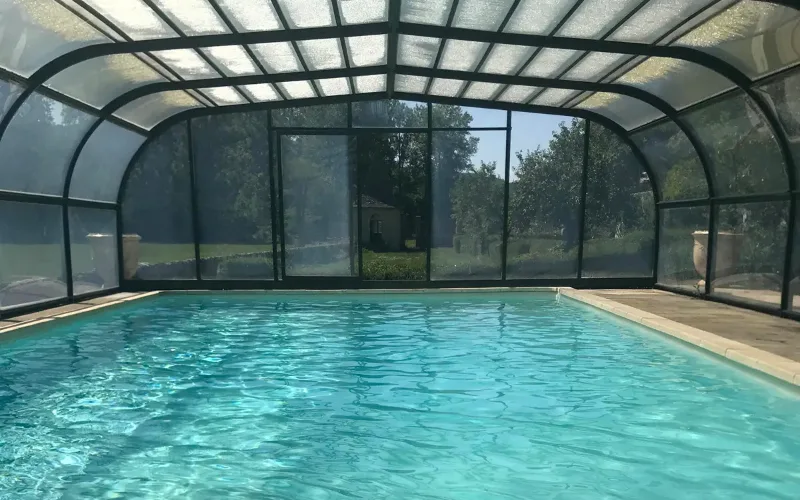 Piscine couverte et chauffée avec vue sur le parc et les arbres environnants