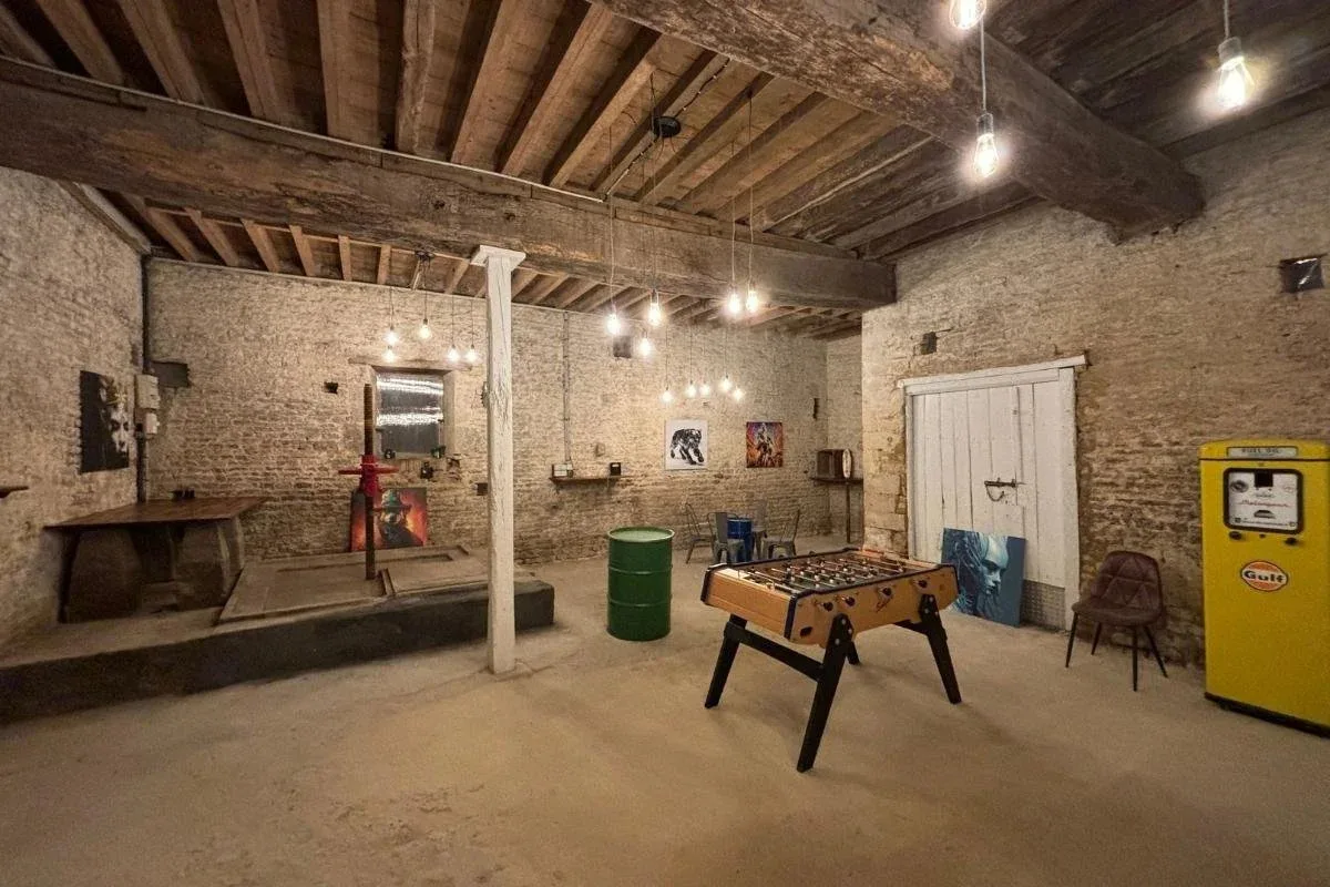 Salle de jeux voûtée en pierre avec baby-foot et décoration vintage dans une dépendance