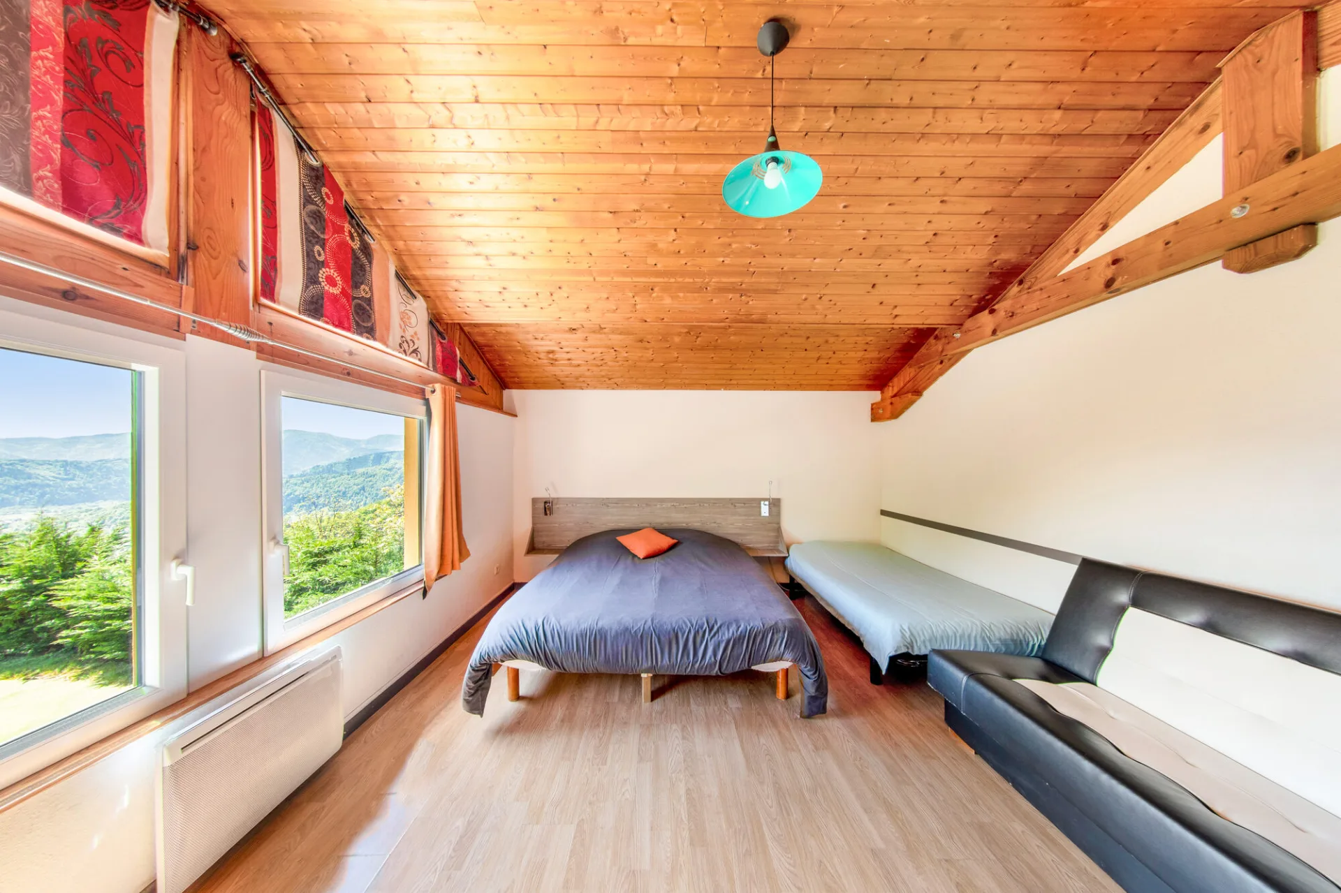 Chambre lumineuse avec lit double, lit simple et vue panoramique sur les montagnes