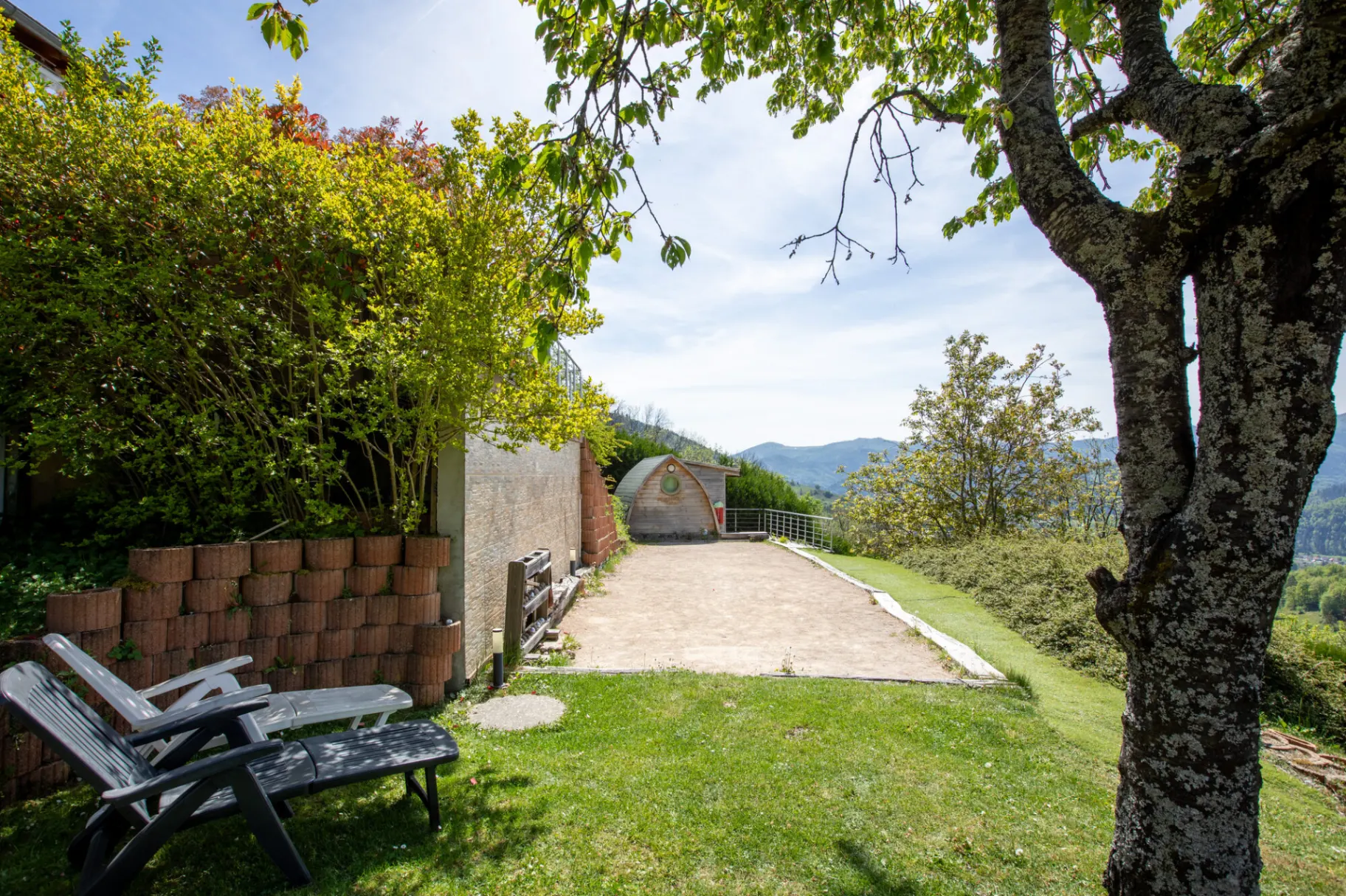 Terrain de pétanque aménagé dans le jardin avec vue dégagée sur la vallée vosgienne