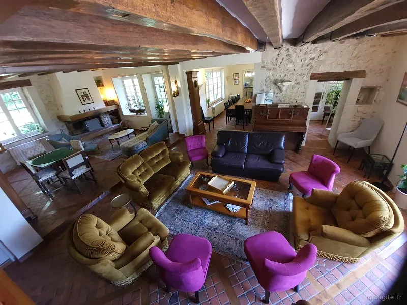 Le salon du gîte de la roue avec canapés et fauteuil et coin cheminée