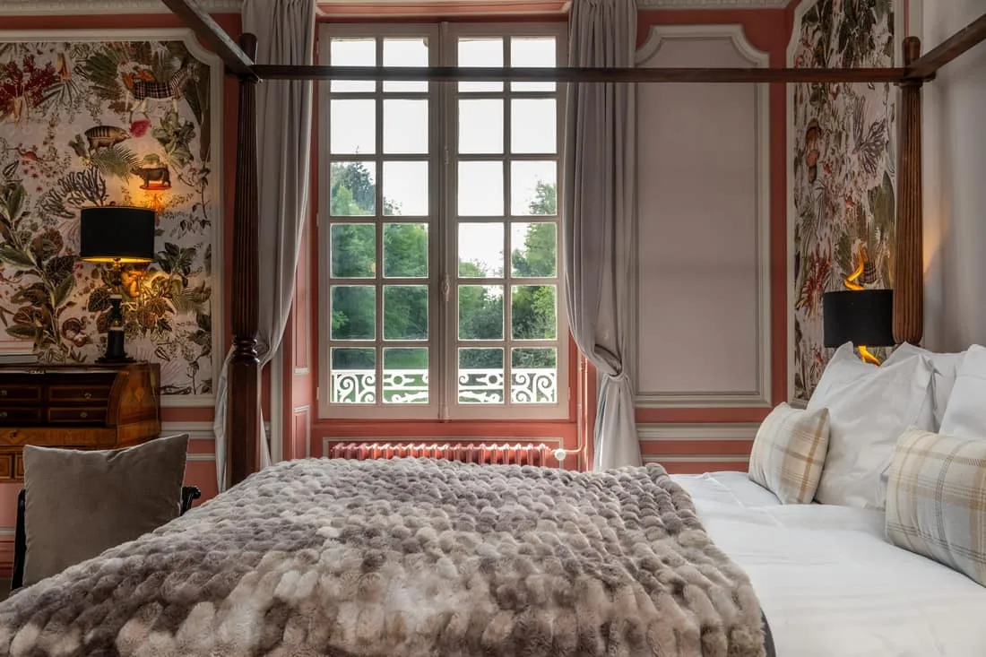 Chambre avec lit à baldaquin et papier peint floral