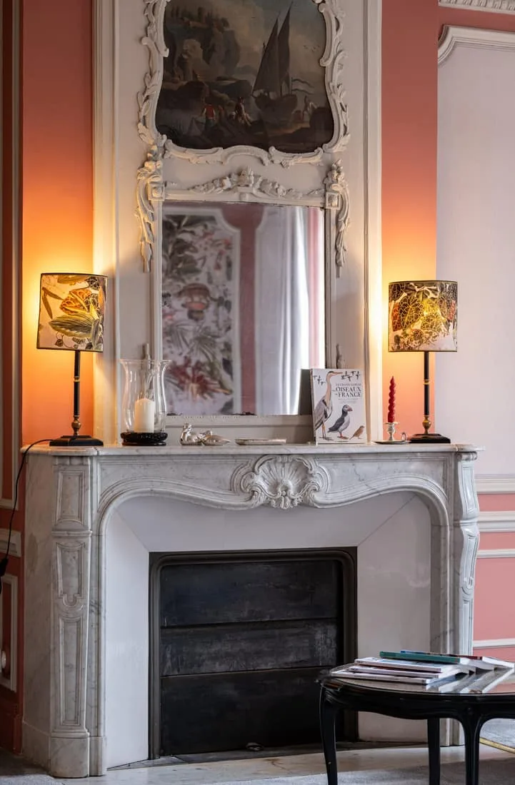 Salon élégant avec cheminée en marbre sculpté et boiseries