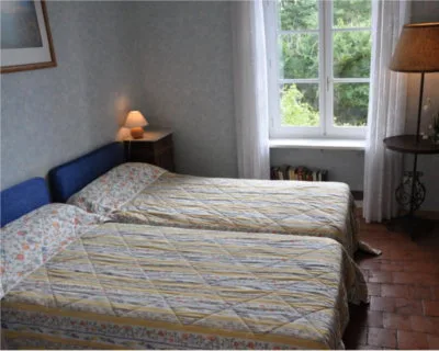 Chambre avec deux lits jumeaux et fenêtre donnant sur le jardin