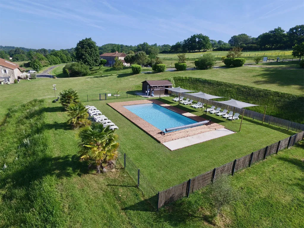 Vue aérienne de la piscine chauffée 12x6m entourée de transats et de palmiers
