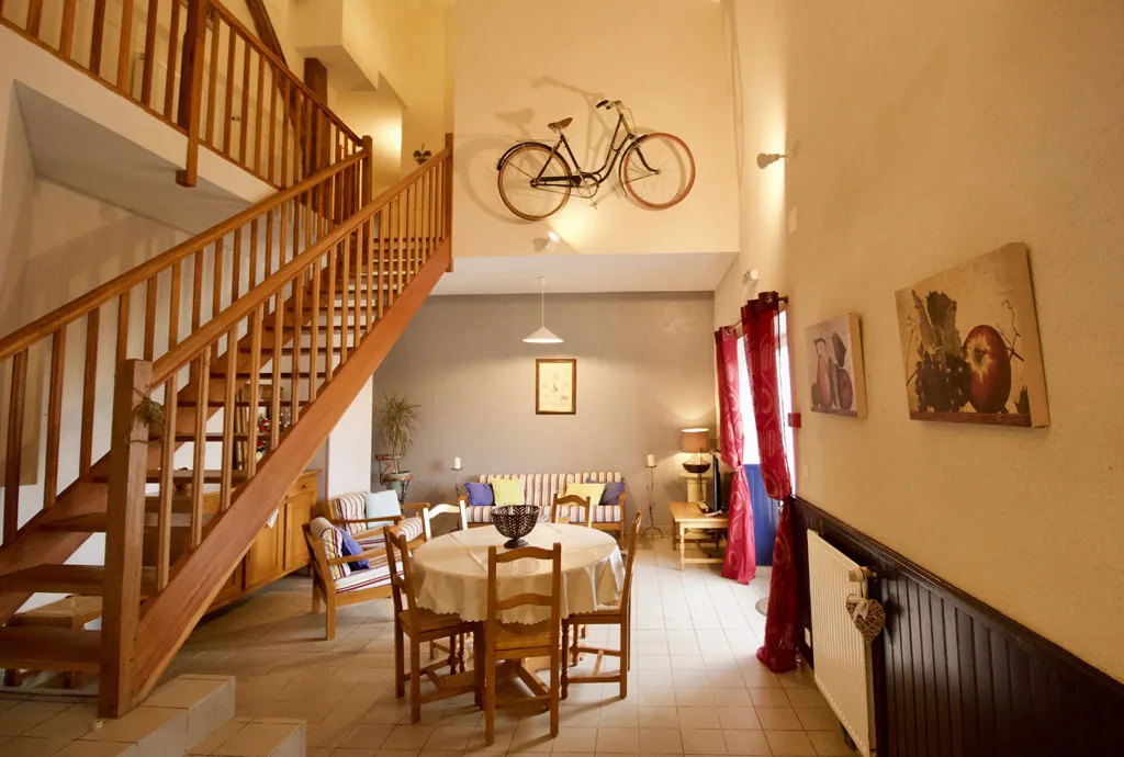 Grand hall d'entrée sous mezzanine avec vélo suspendu en décoration