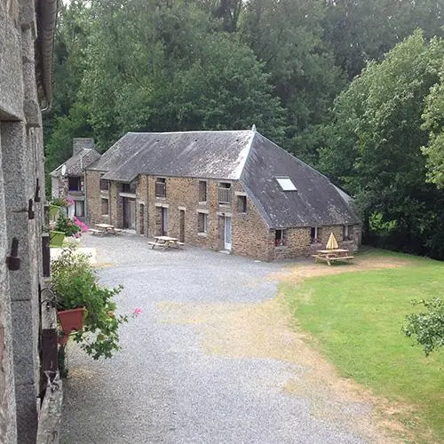 Cour intérieure et bâtisse ancienne en pierre avec parking gravillonné
