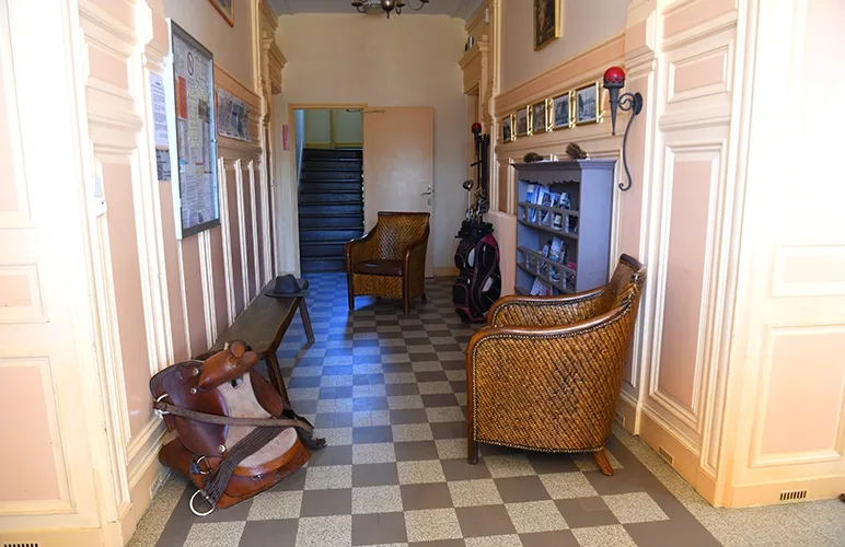 Hall d'entrée du château avec sol en damier et mobilier d'époque