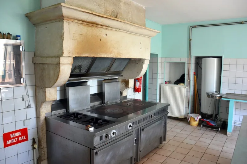 Cuisine professionnelle équipée avec piano de cuisson, adaptée aux repas de groupe