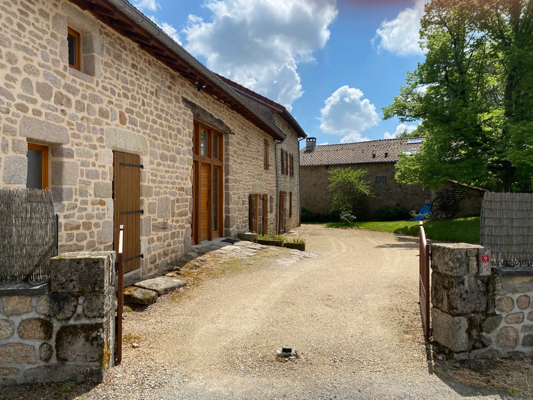 Cour intérieure pavée entre les bâtiments en pierre du corps de ferme