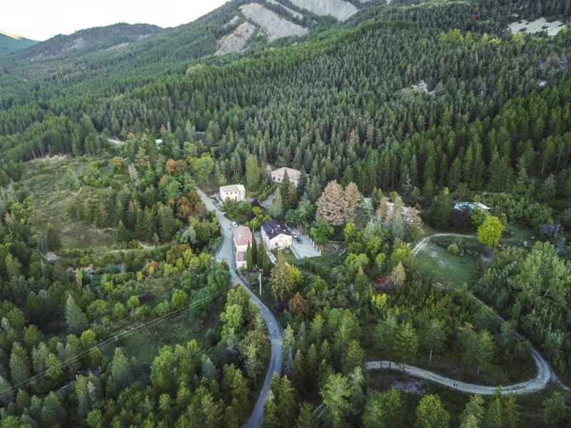Vue aérienne du Domaine de la Clappe niché dans la forêt au pied de la barre des Dourbes