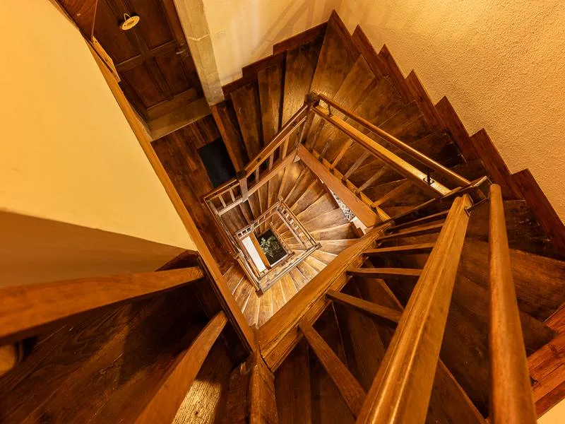 Escalier à vis en bois ancien vu en plongée depuis les étages du donjon