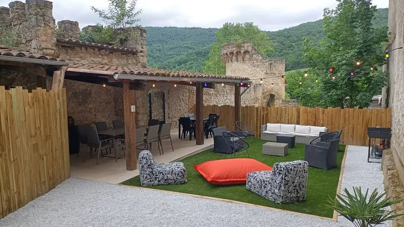 Terrasse extérieure couverte de type guinguette avec salon de jardin et vue sur la vallée