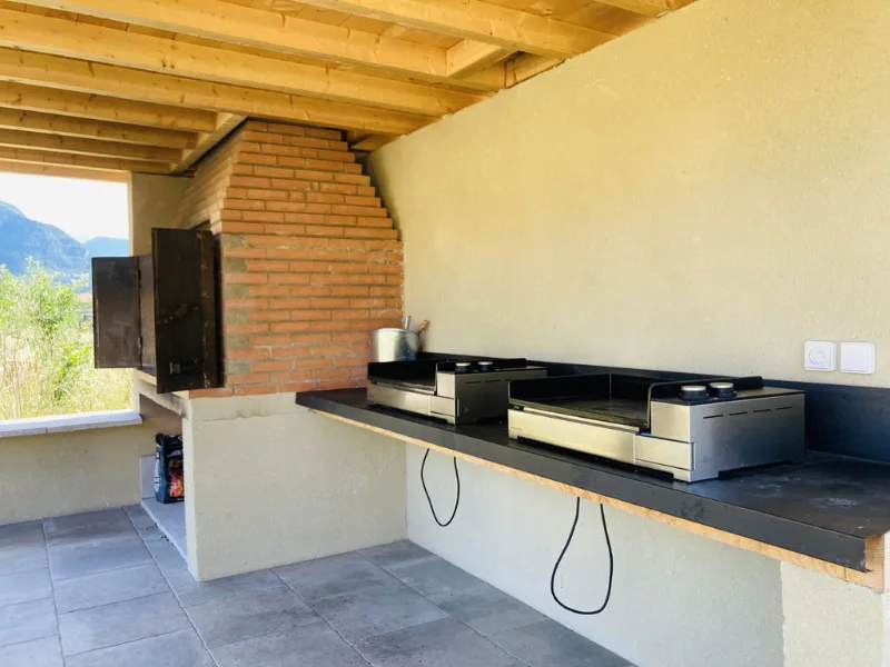 Coin barbecue et plancha extérieur couvert avec four à bois en briques