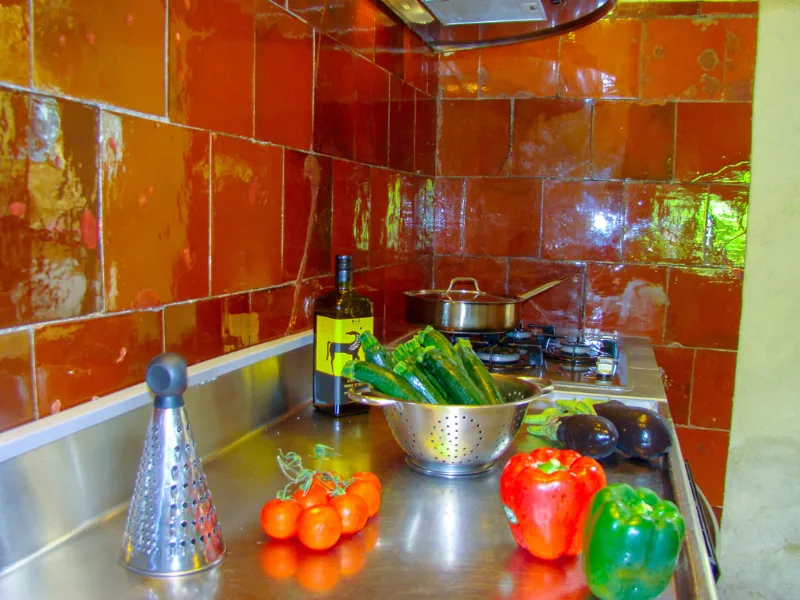 Cuisine rustique avec grand plan de travail en pierre et légumes de saison
