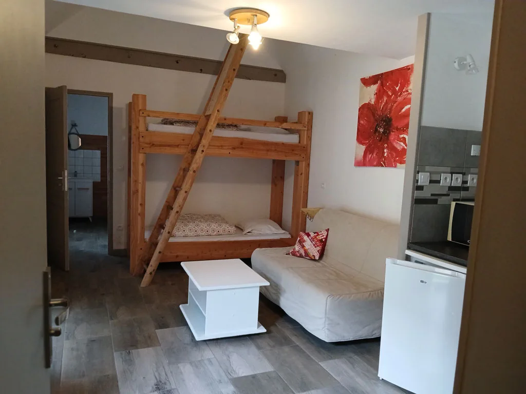 Chambre avec lits superposés en bois sous charpente