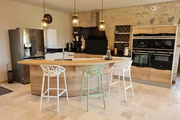 Cuisine moderne avec îlot central en bois et plan de travail en pierre noire