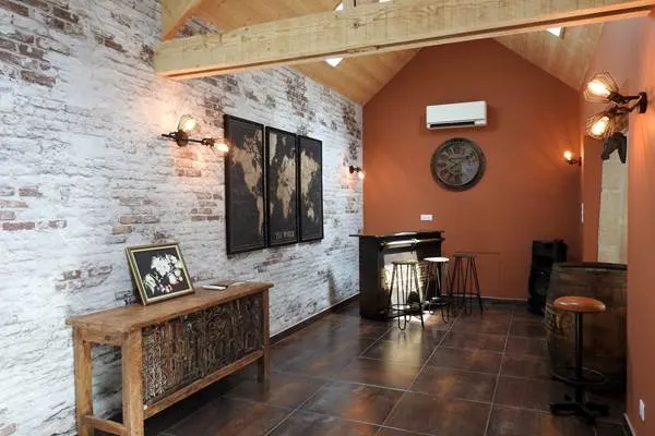 Salon détente avec fauteuils en cuir, cheminée et tapis en peau de vache