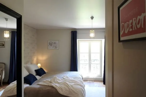 Chambre Diderot avec lit double, miroir et fenêtre à petits carreaux
