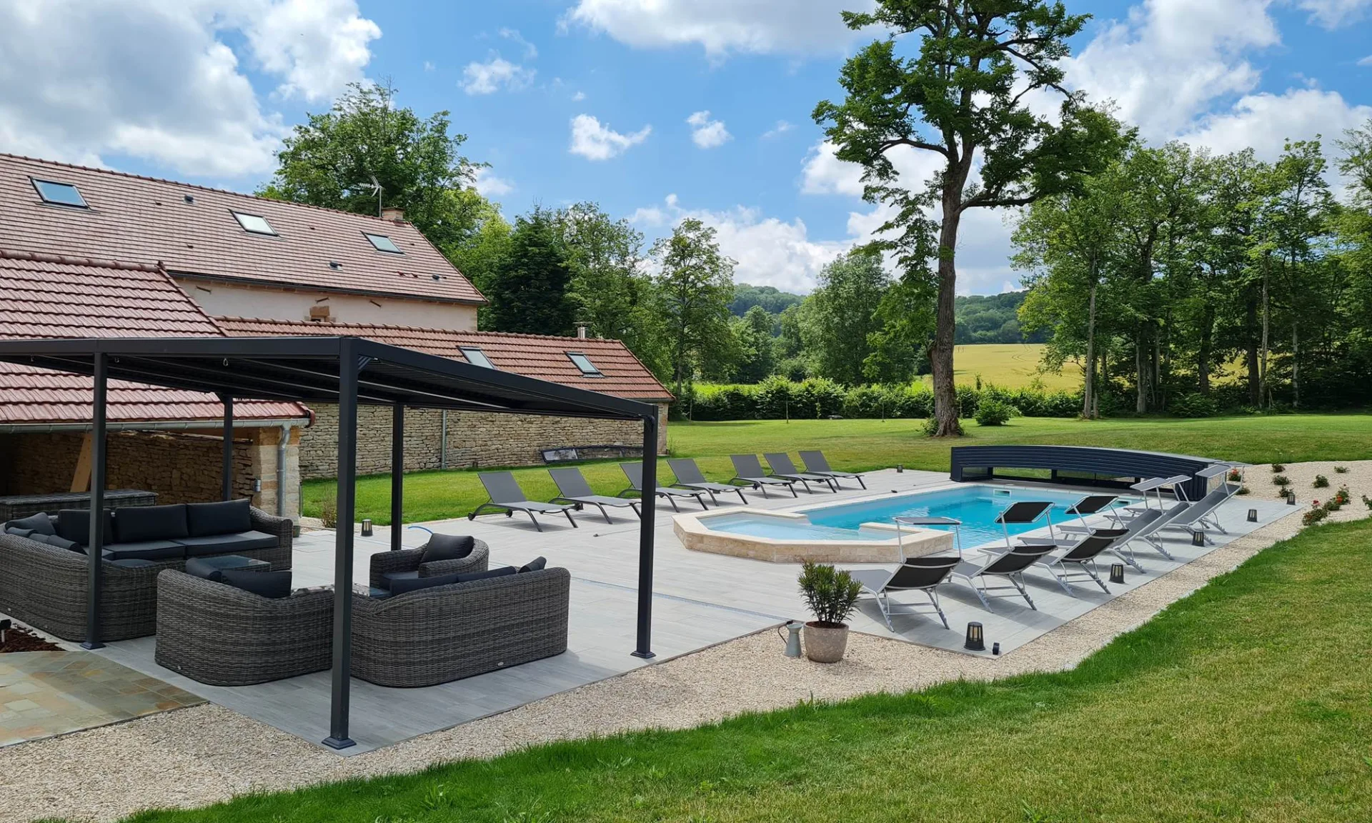 Piscine chauffée et terrasse avec transats sous pergola et salon extérieur