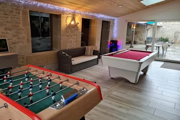 Salle de jeux ouverte sur la terrasse avec baby-foot et billard