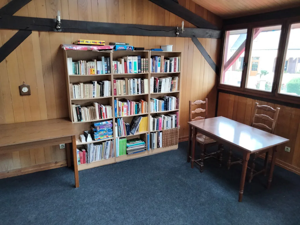 Coin bibliothèque avec bibliothèque en bois, jeux de société et table