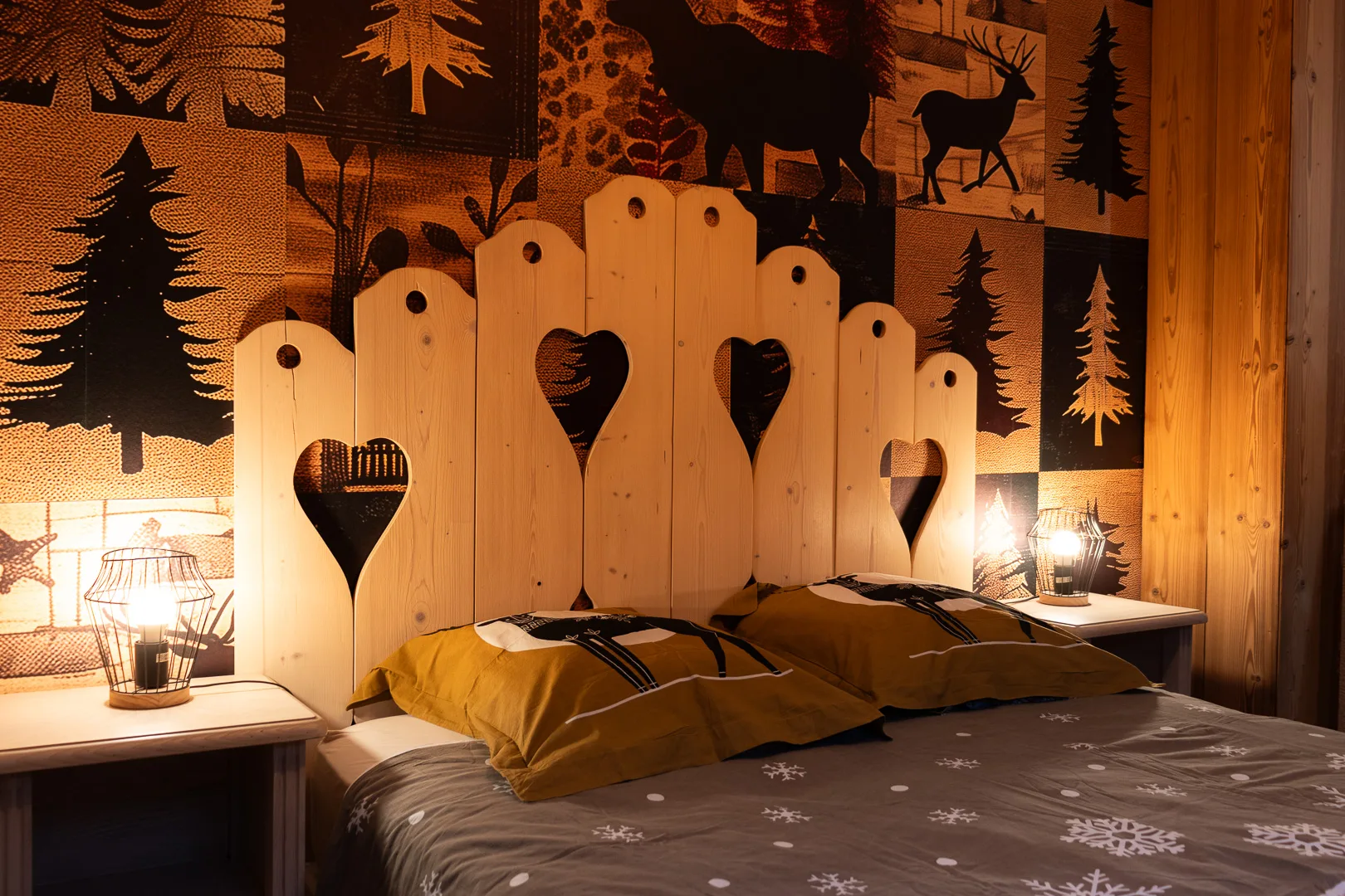 Chambre double avec tête de lit en bois ajourée en forme de cœurs et sapins