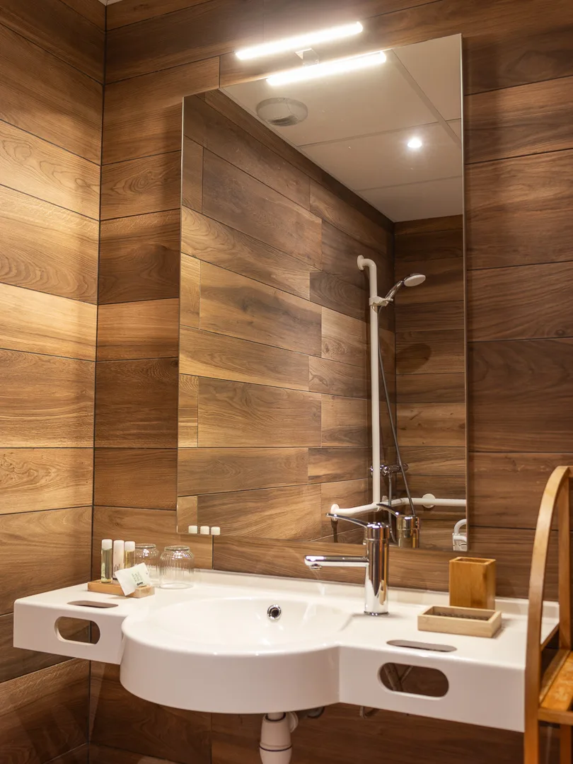 Salle de bain moderne avec vasque suspendue et mur en carrelage hexagonal