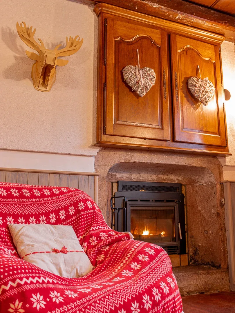 Coin cheminée cosy avec plaid à motifs et décoration montagnarde