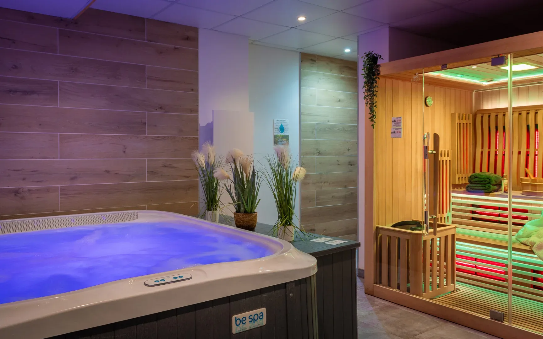 Espace bien-être avec spa extérieur illuminé et sauna infrarouge vitré