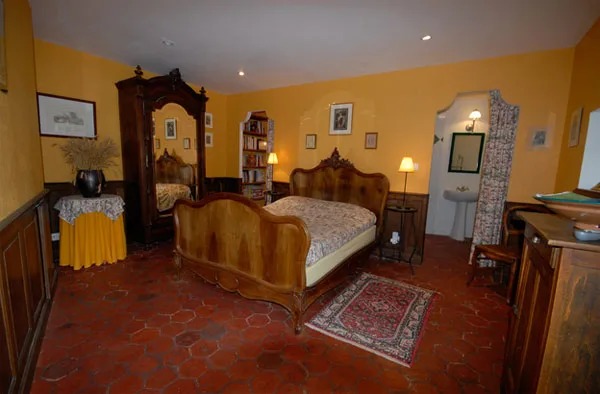 Chambre avec lit ancien en bois sculpté et armoire