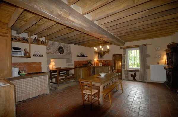 Cuisine et salle à manger rustiques avec poutres au plafond et grande table en bois