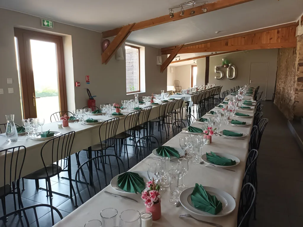 Salle de réception en pierre décorée pour un anniversaire avec tables et guirlandes